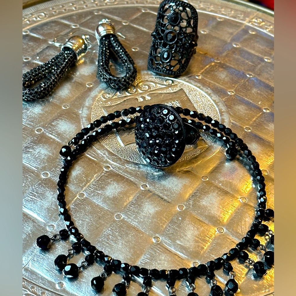 four pieces of jewelry sit earrings two rings in the necklace